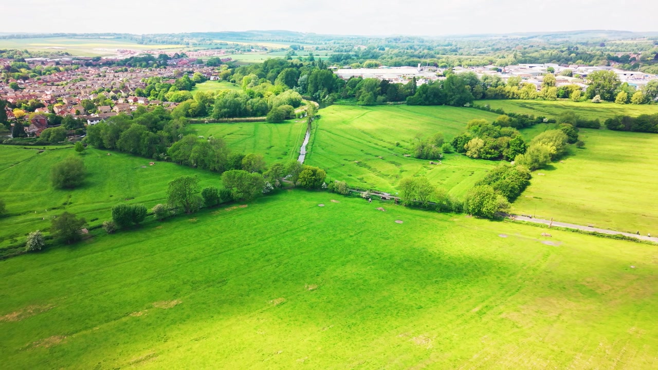 Ujęcia z drona łąk wodnych Salisbury w Wiltshire, pokazujące otwarte zielone pola, linie drzew, koryta rzek, wiejski krajobraz, pobliskie zabudowania i szerszy krajobraz wiejski. Przydatne do tematów związanych z Wielką Brytanią.