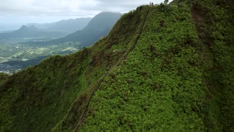 un excursionista subiendo las escaleras haiku, o escalera al cielo, en oahu, hawaii