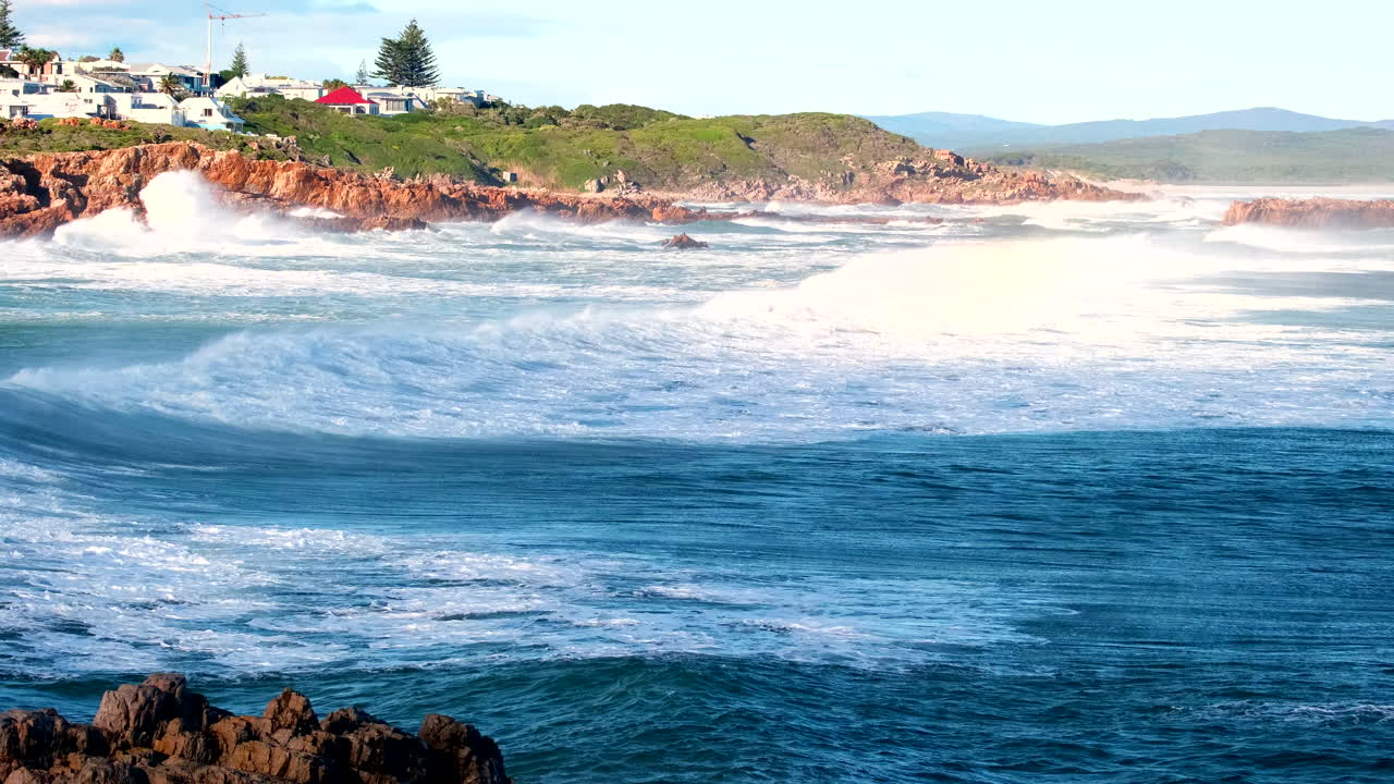 Atlantic ocean waves roll in and sea spray blows over crest, slow motion