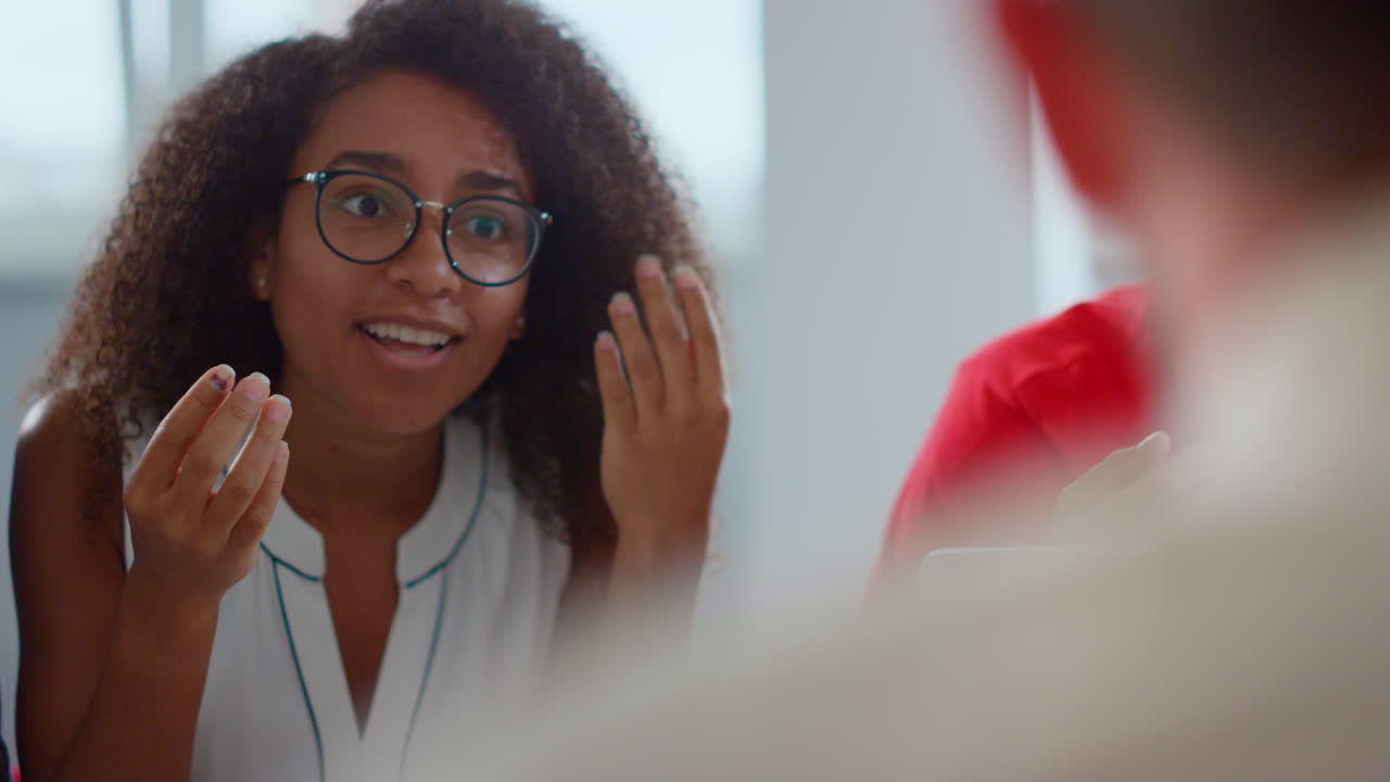 Empresária africana conversando com um homem desconhecido no escritório. Mulher discutindo com colegas.