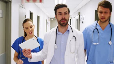 equipo de médicos interactuando mientras caminan por el pasillo