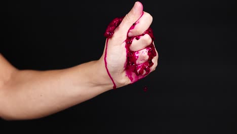 hand squeezing dragon fruit, juice dripping down