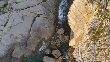 Zoom-out-of-sea-waves-breaking-on-rocky-coastline