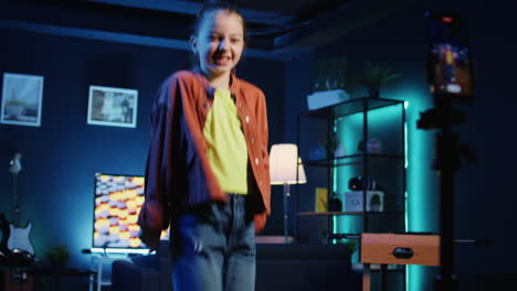 kid taking part in trends, performing viral choreography on popular song using smartphone on tripod