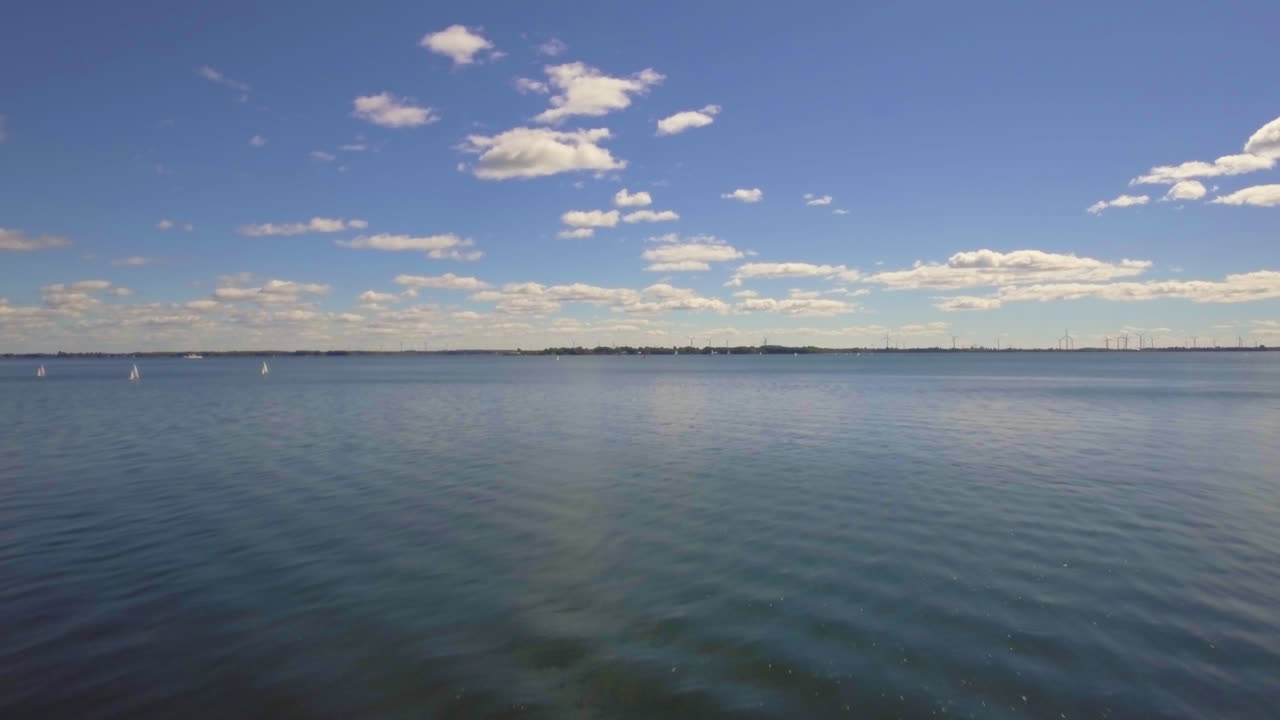 Flying over crystal water, ocean, sea, transparent water with aeolians in the distance. Flying above crystal clear waters, Ireland.