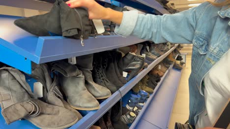 A woman examines used shoes in a secondhand store 4k 2025 08 04 08 22 01 utc.mov | adventure, antiques, autumn, bag