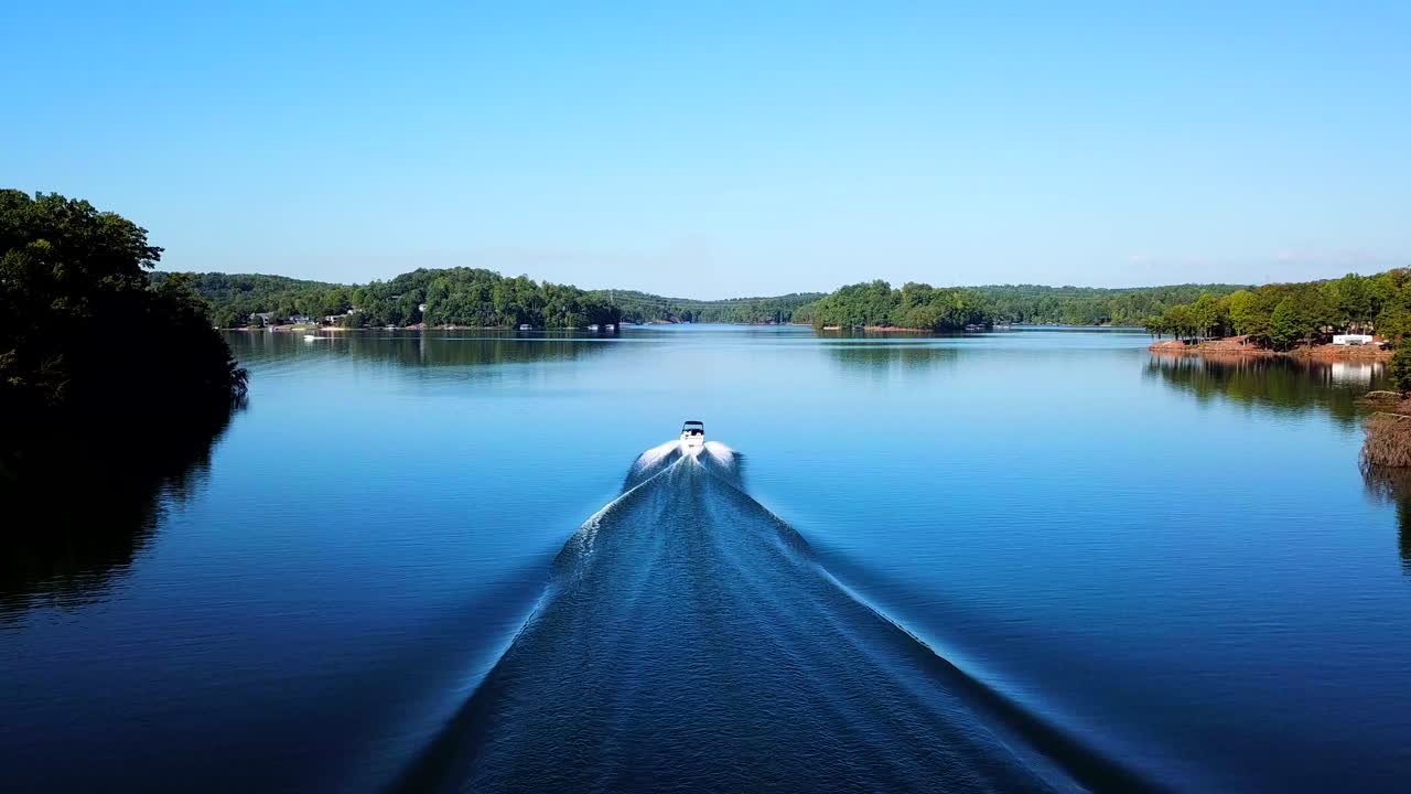 lancha deslizándose rápidamente en el lago entre colinas y bosques