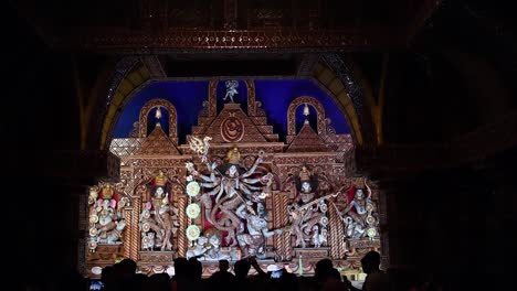 indian visitors taking photos of hindu goddess durga idol in pandals or temples in festival season