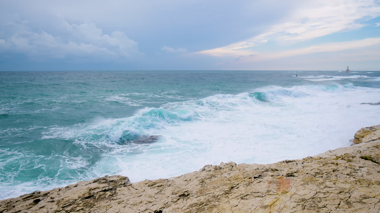 olas del mar rompiendo en rocas submarinas creando crestas y aplastando en costas rocosas, faro porer