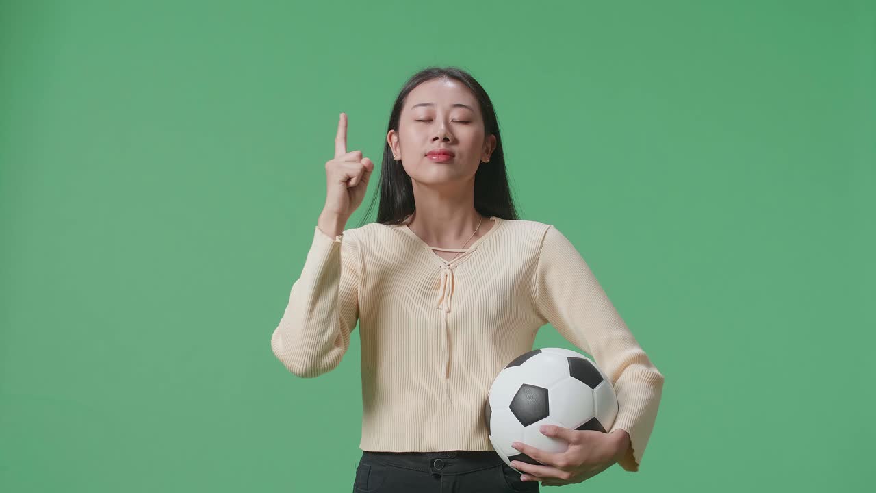 여자 는 축구 공 을 들고 생각 하고 있다