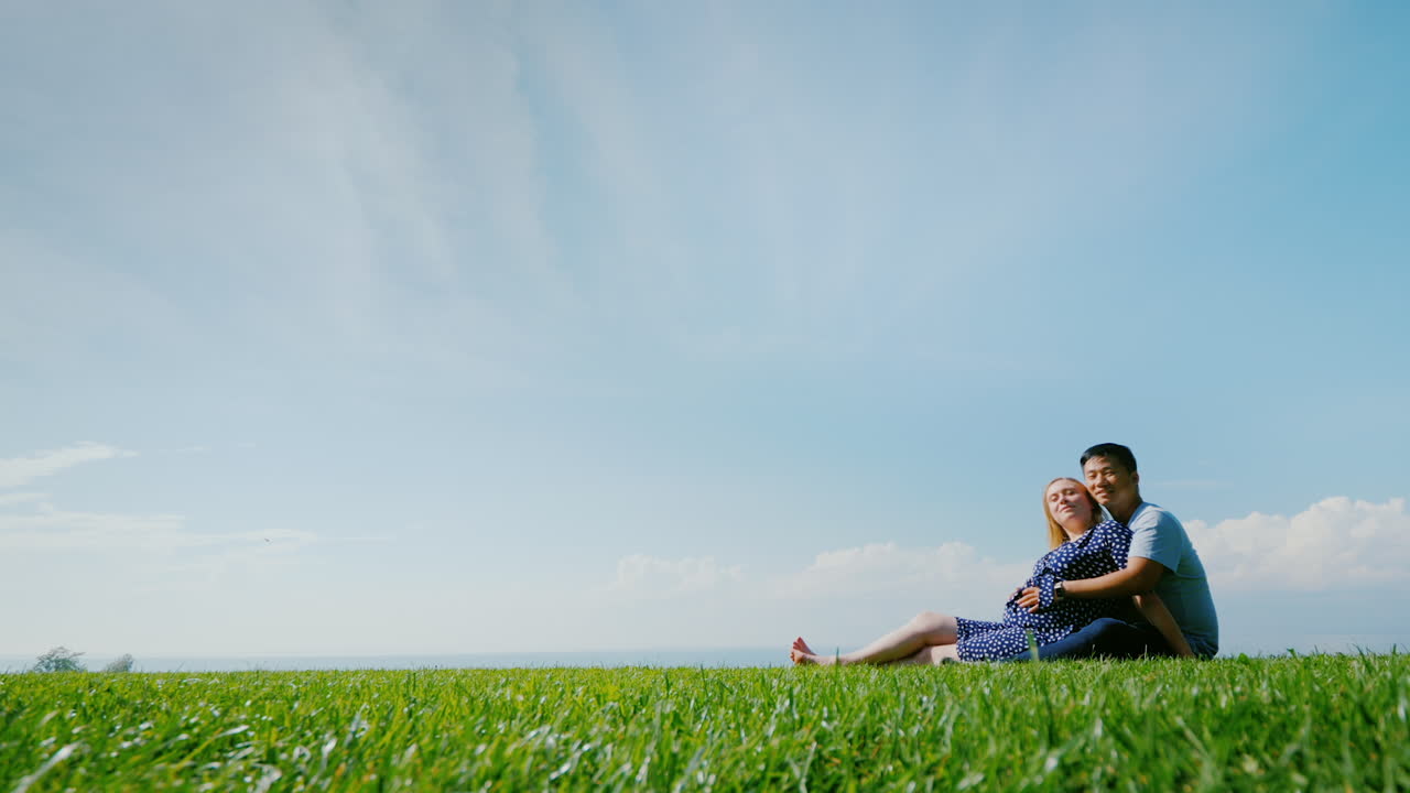 아름다운 자연을 감상하며 푸른 잔디에서 쉬고 있는 다민족 커플