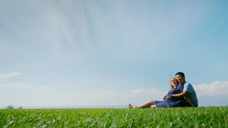 multi-ethnic couple resting on the green grass admiring the beautiful nature