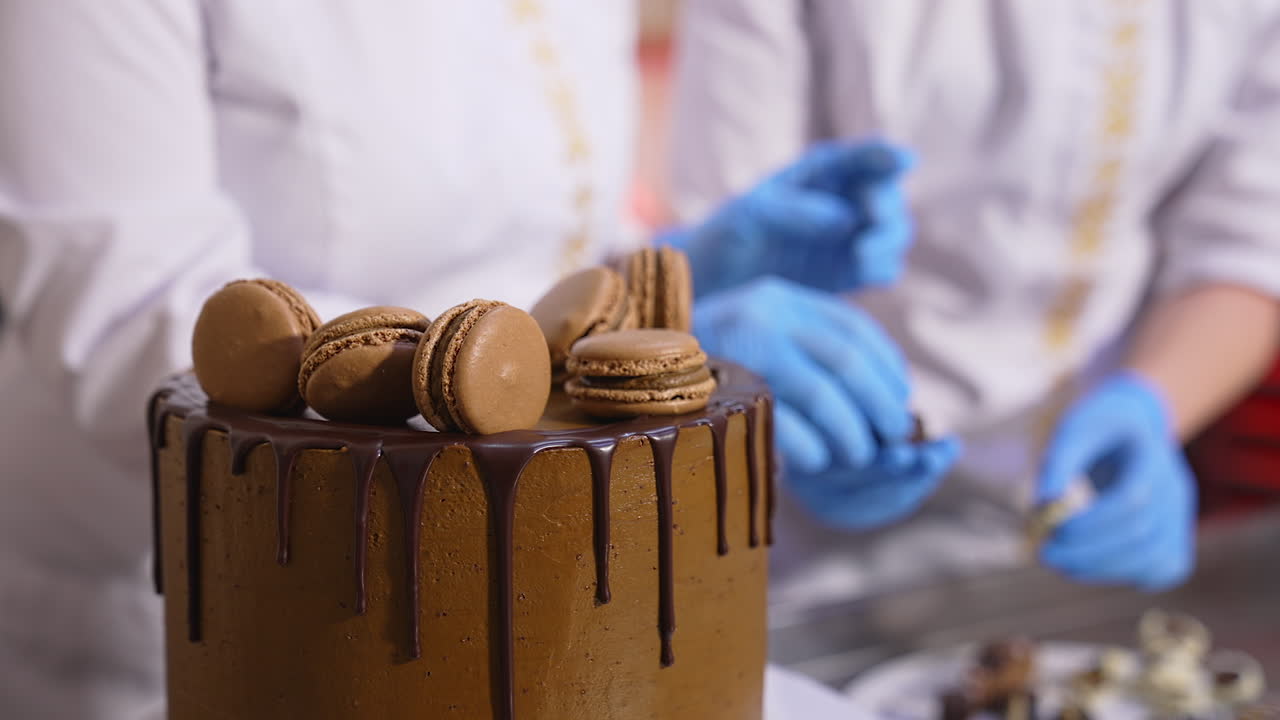Chocolate macaroons cookies are put on top of the cake. Candies are laid among the biscuits. Close up.