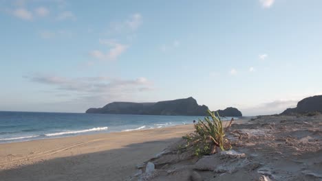 panoramic wide shot dunes on deserted beach, islet background porto santo island