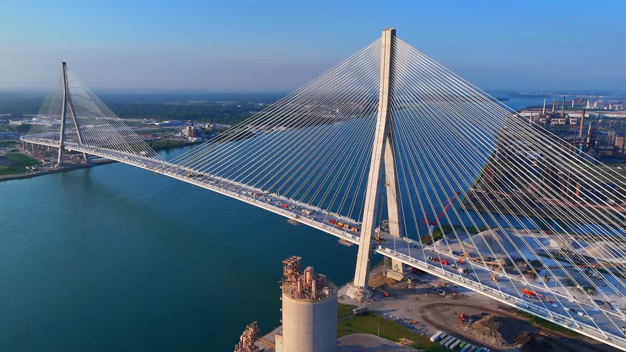 Aerial drone view of Gordie Howe Bridge crossing wide Detroit River below