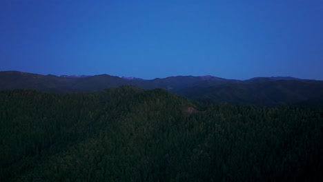 Night-time-drone-shot-in-the-dark-of-a-mountain-and-forest-area