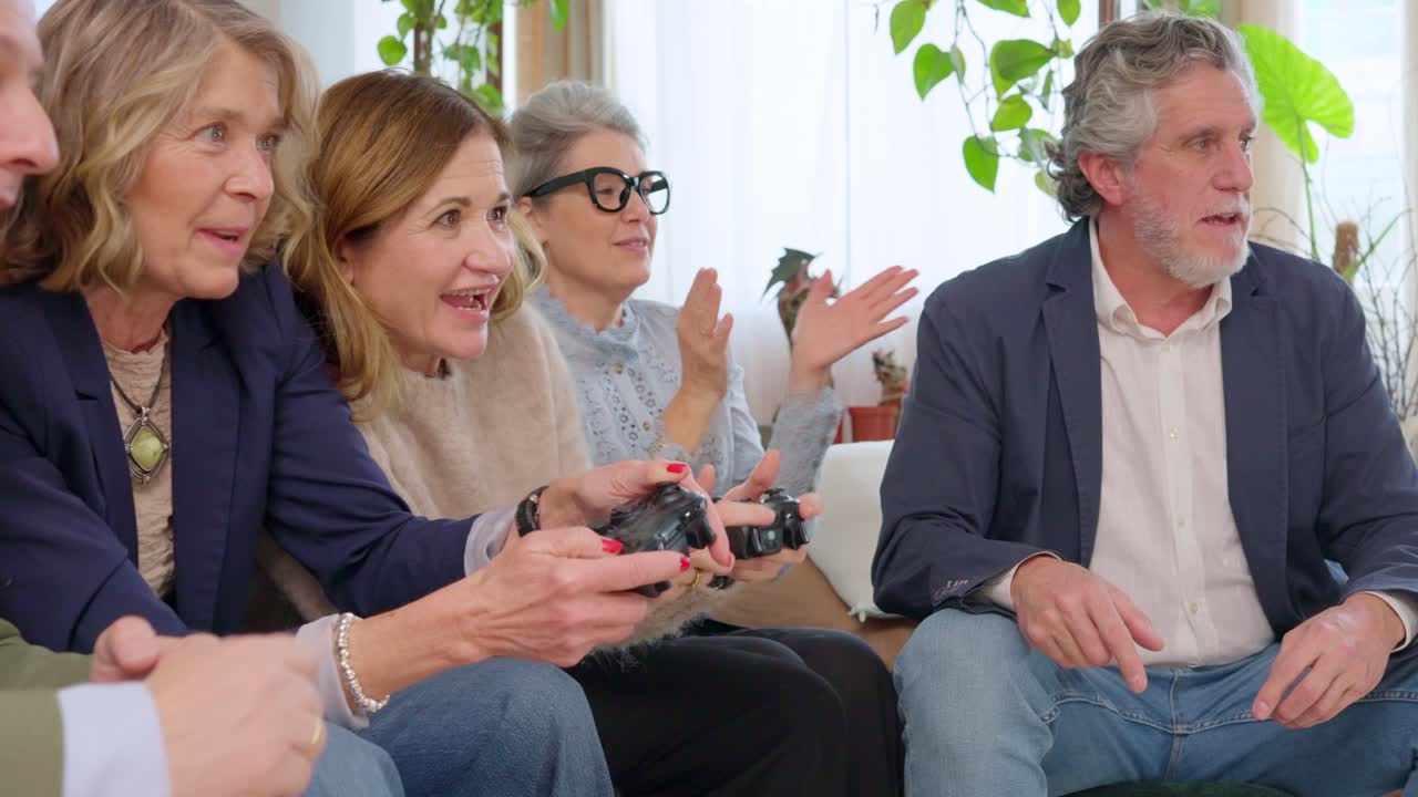 Amici senior felici che giocano insieme ai videogiochi a casa