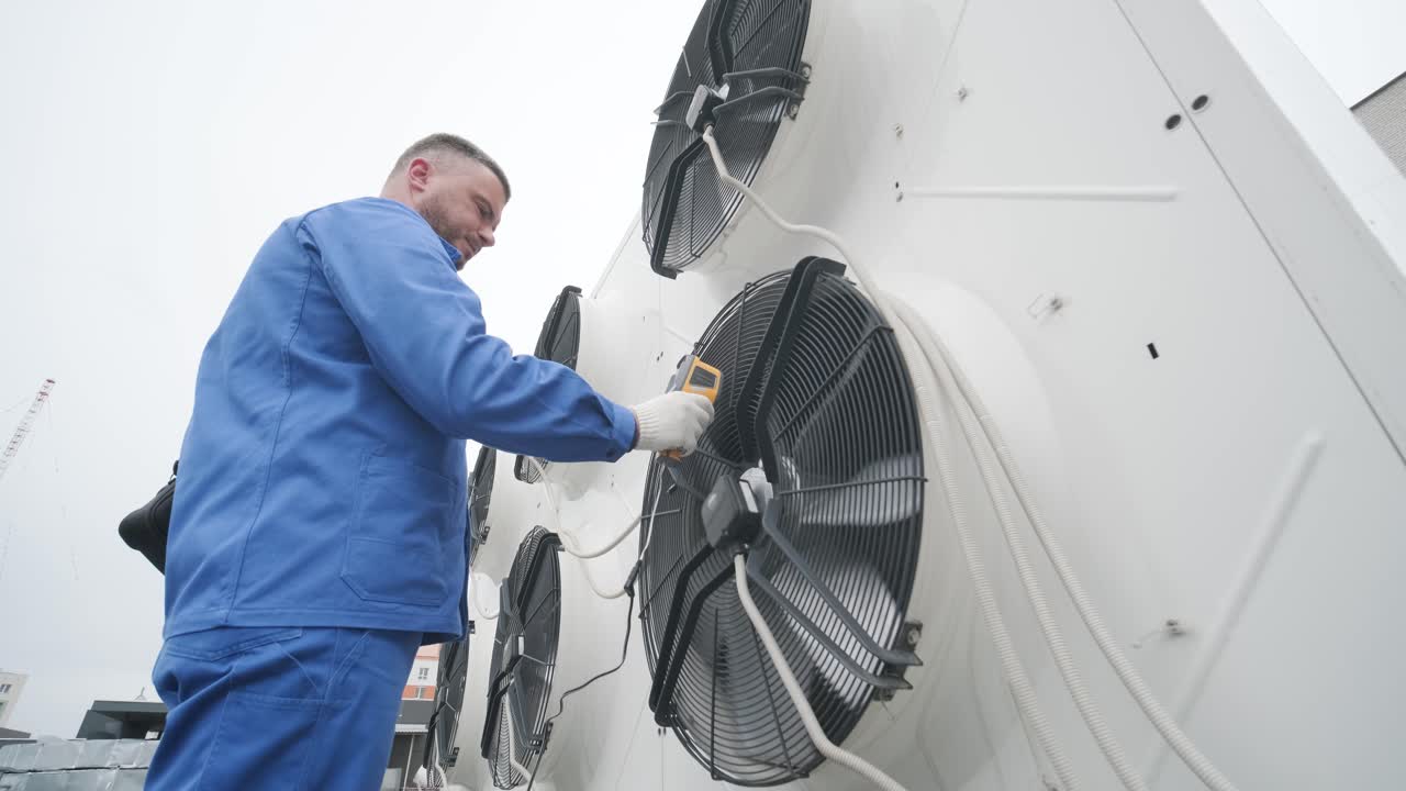Le technicien utilise un thermomètre infrarouge à imagerie thermique pour vérifier l'échangeur de chaleur de l'unité de condensation