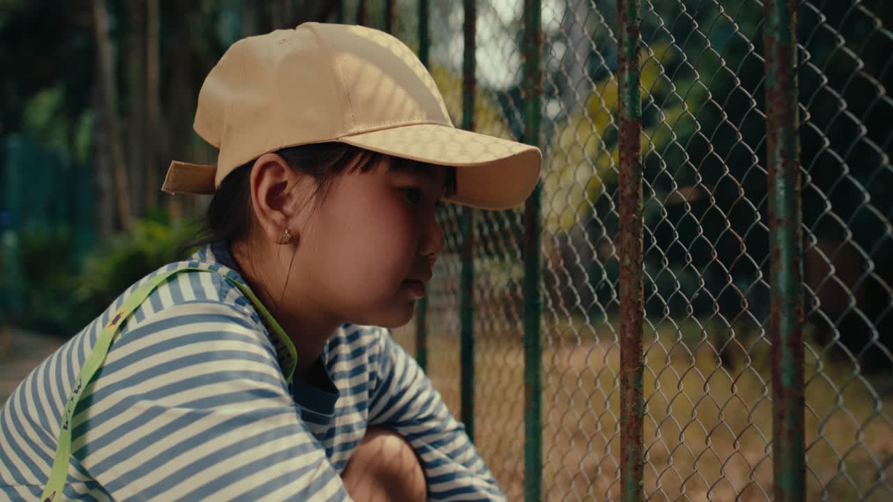 Niña junto a una valla