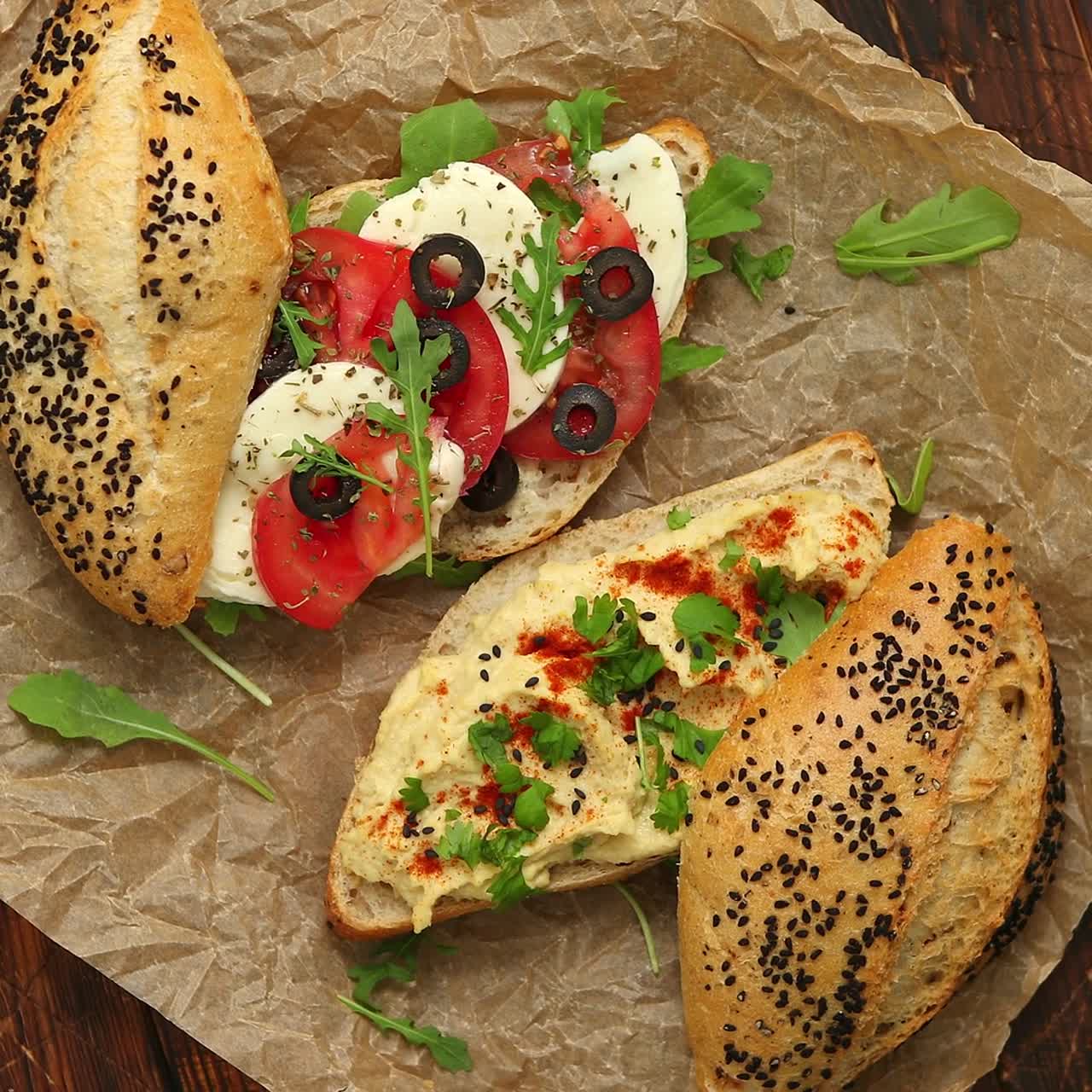Due deliziosi panini con hummus, pomodoro, mozzarella, erbe aromatiche e olive