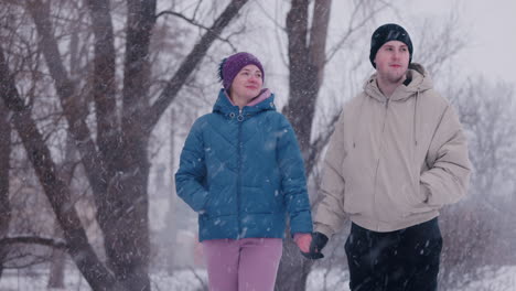 couple walking hand in hand in the snow