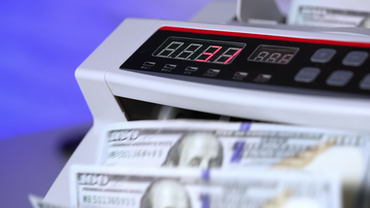 Electronic cash money counter. Counter machine is processing american money banknotes. Mechanism for bank financial operations. Finance concept. Close-up.