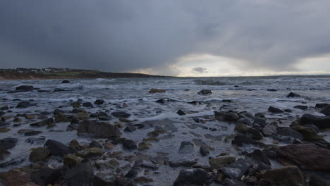 waves lapping on a beach at high tide on the coast at the start of a storm in the east coast of scotland in february 2024 low angle on the rocks angle 6