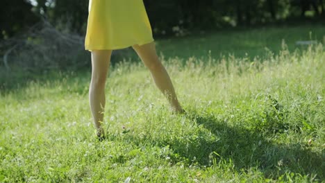 woman in yellow dress dancing gracefully in summer park