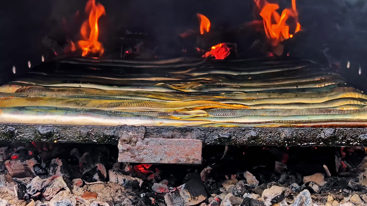 Close-up of fresh fish grilling over hot coals with open flames, smoky outdoor cooking scene with crispy skin and glowing embers—rustic campfire barbecue food.