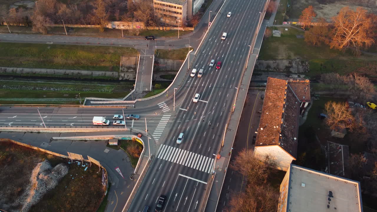 Tilt down above busy intersection with visible tram rails and turning cars in city center