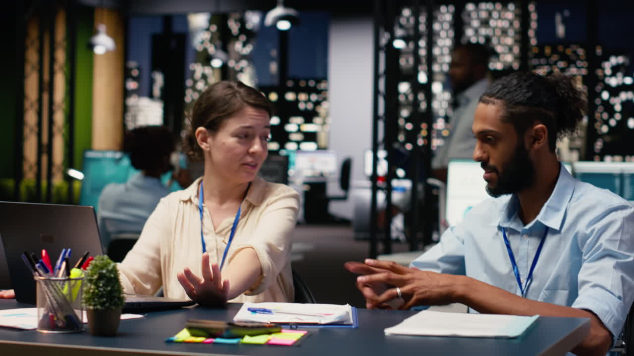 Woman and middle eastern assistant in wheelchair collaborating on tasks at night