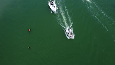 Birds-eye-view-of-all-kinds-of-different-boats-entering-and-exiting-the-shot,-on-a-sunny-day-in-the-south-of-england