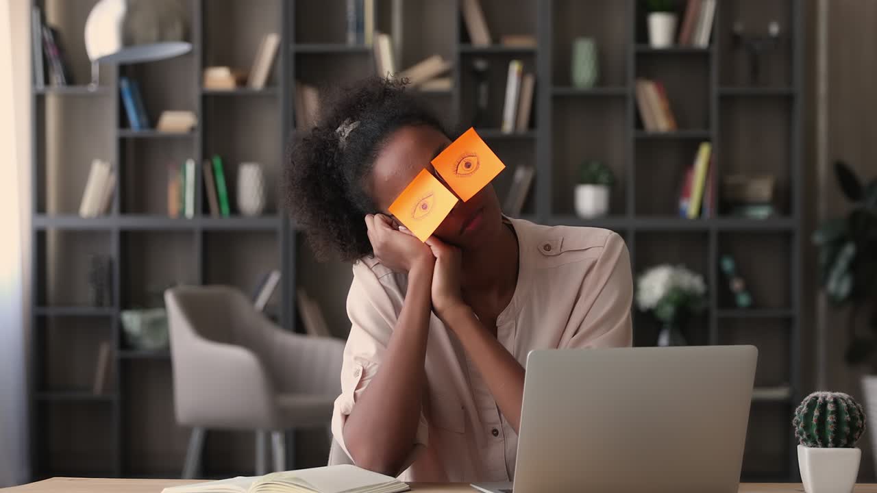 Exhausted young african american business lady fallen asleep at workplace.
