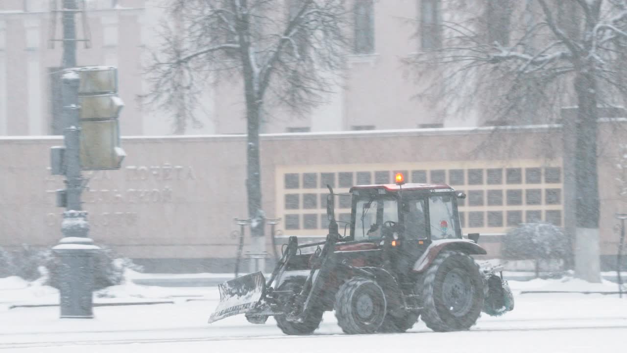 벨라루스 고멜에서 트랙터가 겨울에 눈을 청소하는 눈 폭풍의 날.