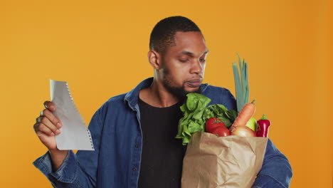 Vegan person checking his grocery shopping list to buy everything he needs