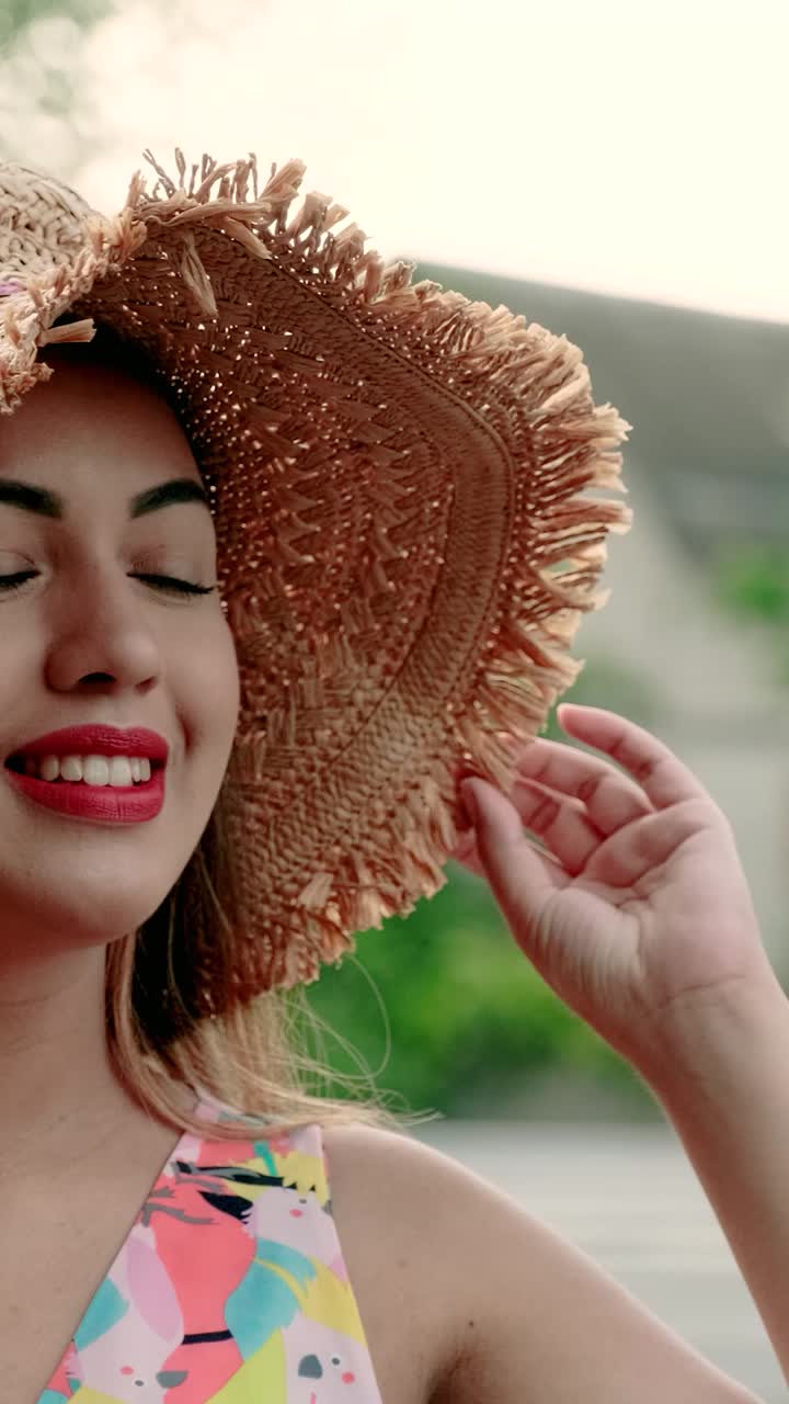 Woman wearing a straw hat and floral dress