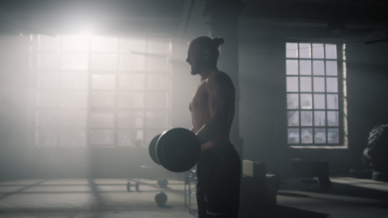 Sportivo che respira affannosamente prima di un esercizio di forza. Uomo che solleva pesi in palestra.