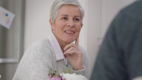 happy-mature-couple-eating-breakfast-together-wife-smiling-enjoying-conversation-with-husband-at-table-sharing-morning-meal-in-kitchen-day-in-the-life-4k-footage