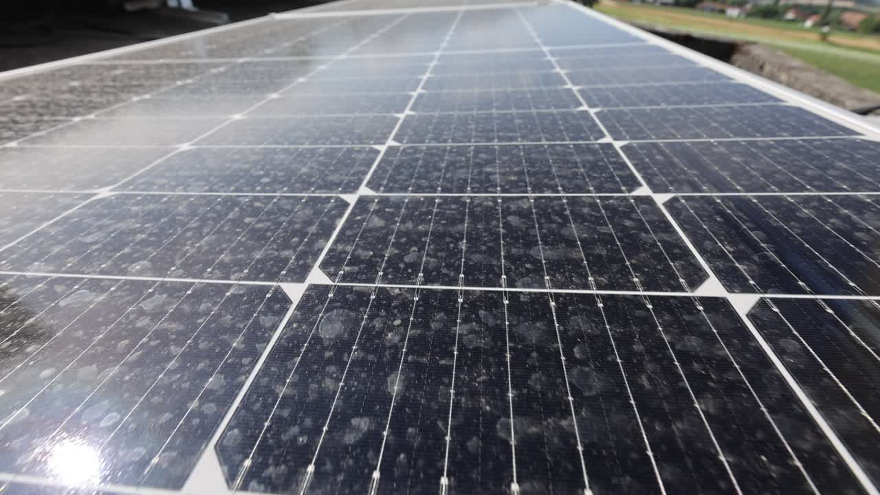 disparo aéreo que muestra unidades conectadas de una granja de paneles solares fotovoltaicos en las montañas durante un día soleado