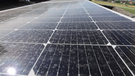 Aerial-tilt-up-shot-showing-connected-units-of-Photovoltaic-solar-panel-farm-in-mountains-during-sunny-day