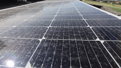 disparo aéreo que muestra unidades conectadas de una granja de paneles solares fotovoltaicos en las montañas durante un día soleado