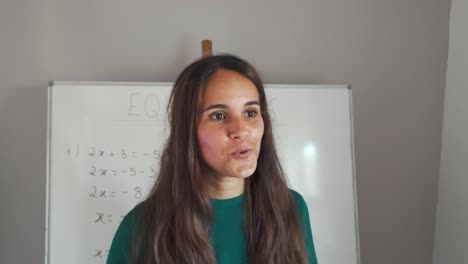 portrait of brunette young girl teaching maths on a blackboard