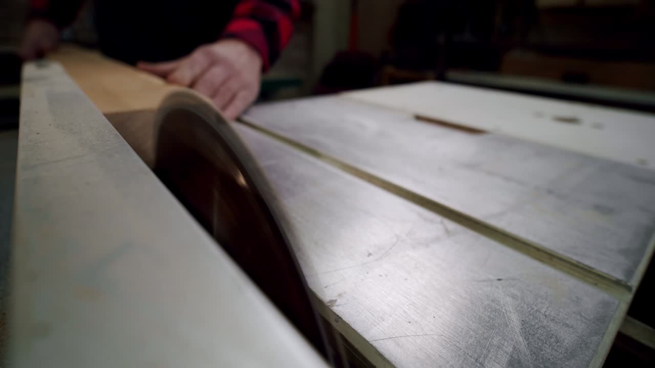 fotografía de cerca. el maestro corta una tabla de madera con una sierra circular en el taller de carpintería de un pequeño fabricante de muebles. cámara lenta. vercion 2