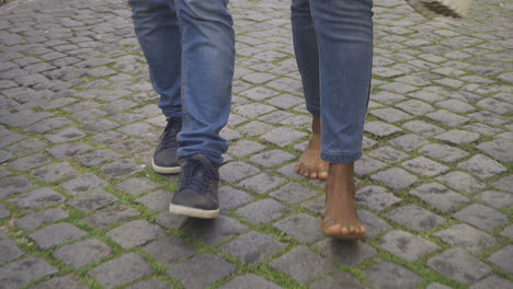 front view of young man walking with barefoot woman.