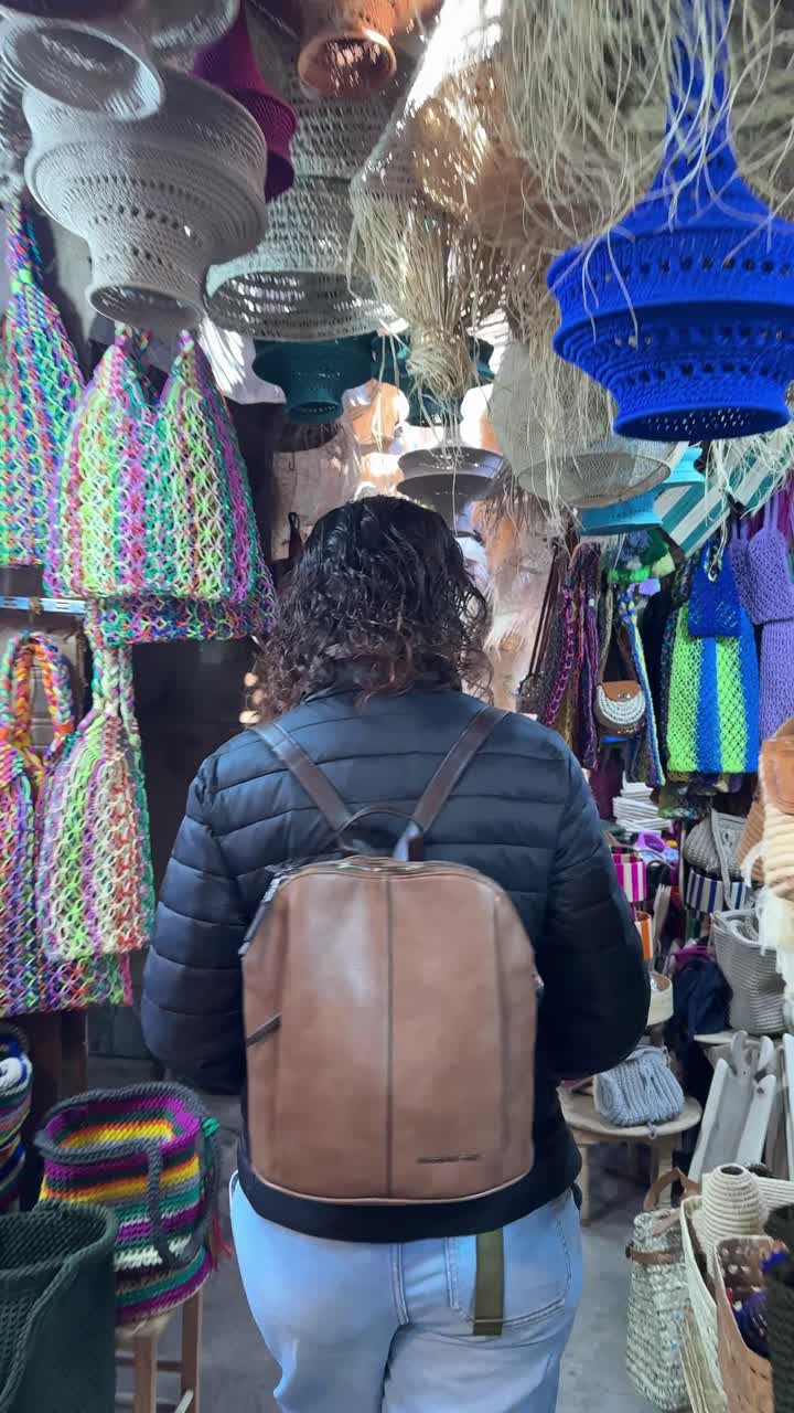 Woman Walking and Browsing Handmade Crafts in a Vibrant Market