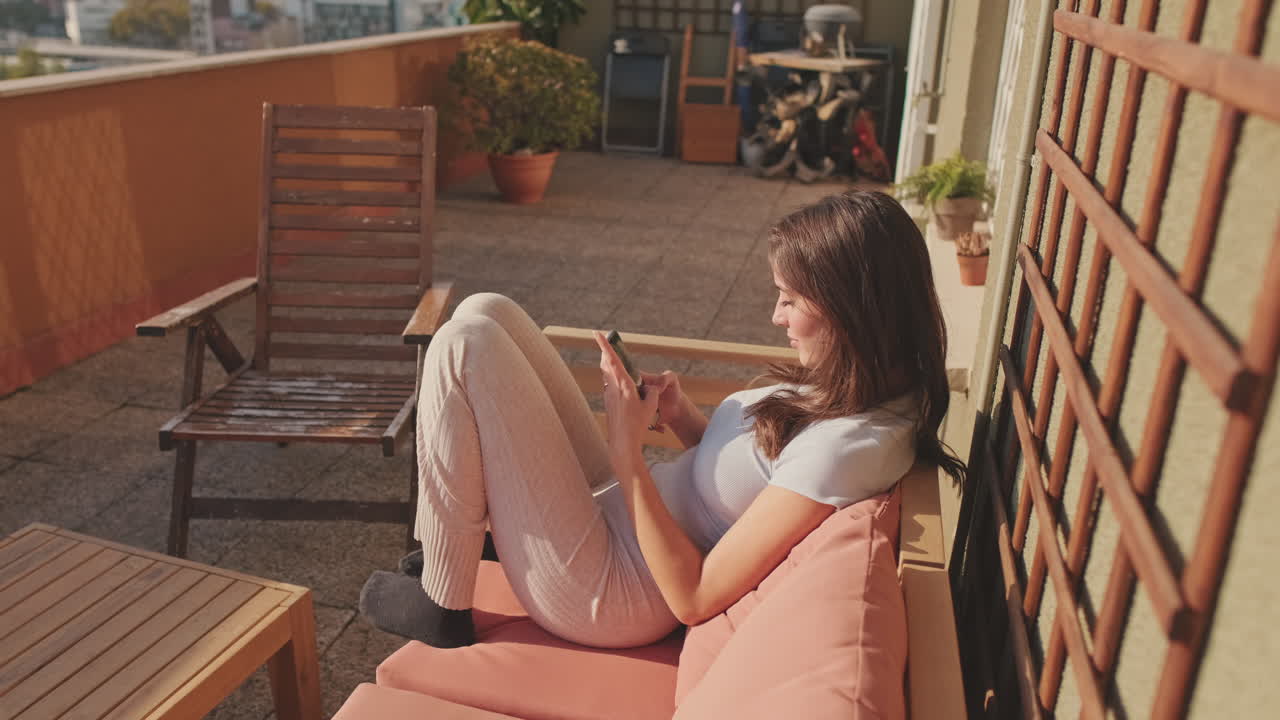 Donna che si rilassa sul balcone con il telefono