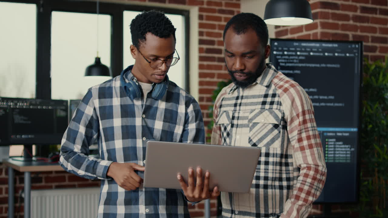 Software programmers talking about algorithms holding laptop switching focus on cloud programer writing code