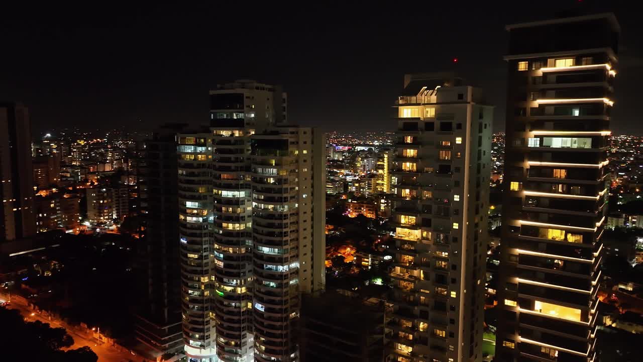 toma de órbita aérea de bloques de apartamentos de iluminación en la avenida anacaona en la noche en santo domingo