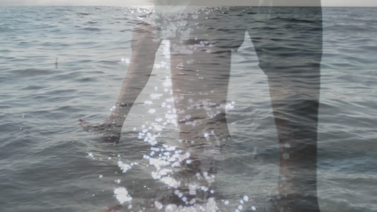 해변에서 함께  ⁇ 고 있는 백인 부부의 낮은 부분에 대한 바다 파도의 복합 비디오