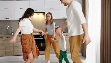 feliz familia bailando salta en el fondo de moderno apartamento diseño cocina padre madre padres y 2 hijos hijo y hija activo feliz